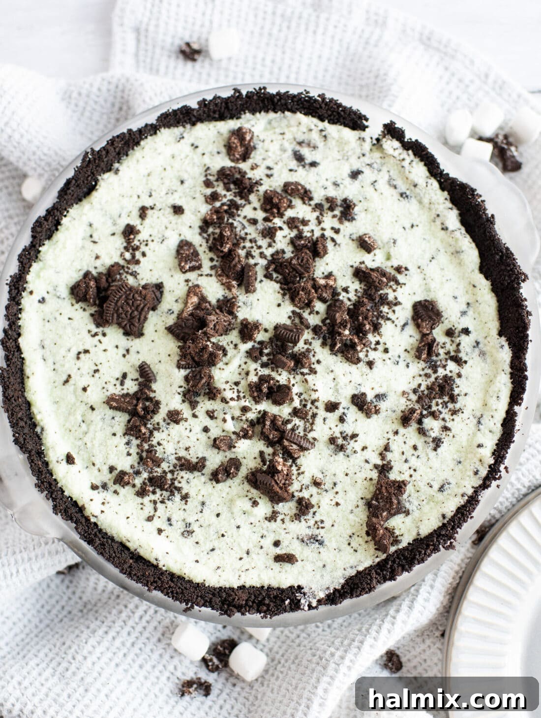 Emerald Mint Delight 3 Overhead view of a beautifully prepared Grasshopper Pie, showcasing its vibrant green filling and dark chocolate Oreo crust.
