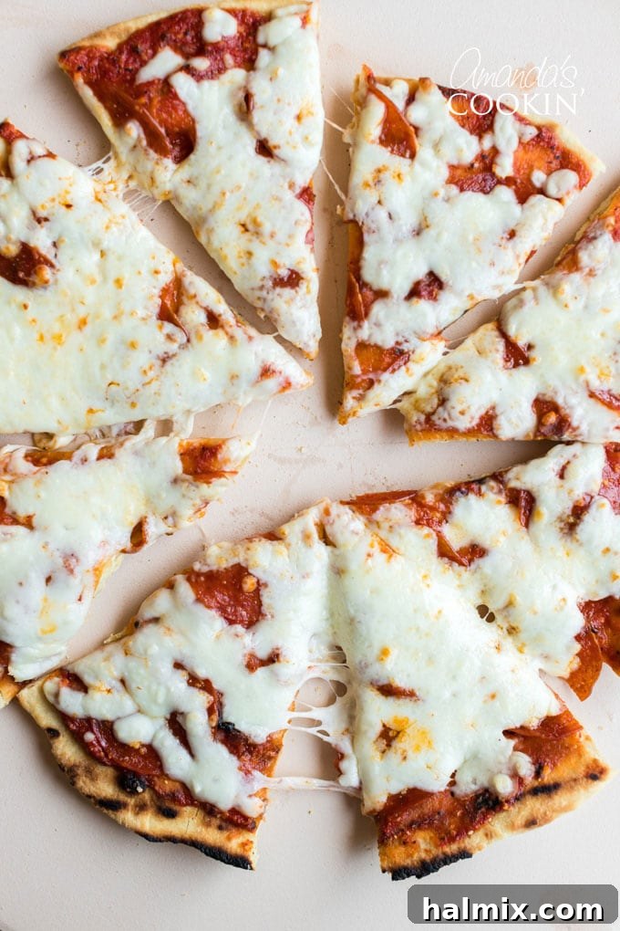 A beautifully grilled cheese pizza, glistening and perfectly cut into slices, ready to be enjoyed.