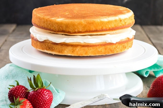 Timeless Vanilla White Cake 11 two cake layers with cream cheese frosting in between on a cake platter