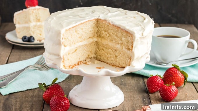 Timeless Vanilla White Cake 14 white cake with two slices removed sitting on a cake plate