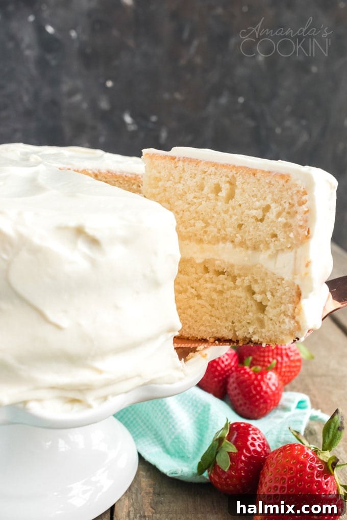 Timeless Vanilla White Cake 5 removing a slice of white cake from platter