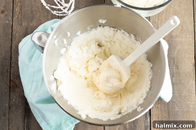 Timeless Vanilla White Cake 10 Folding frosting ingredients together in a bowl with a rubber spatula