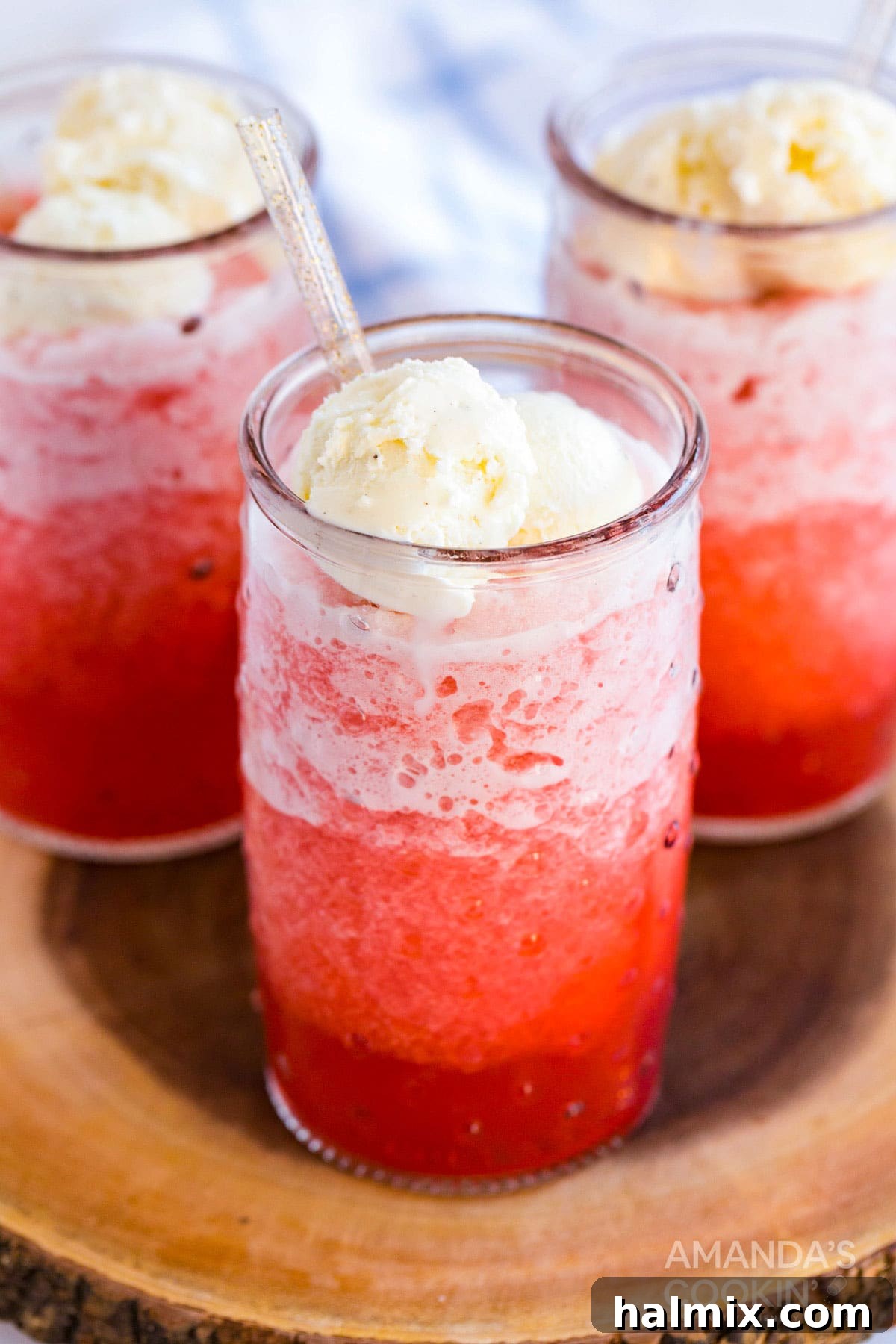 Vibrant red homemade slushies topped with creamy vanilla ice cream, ready to refresh on a hot day.