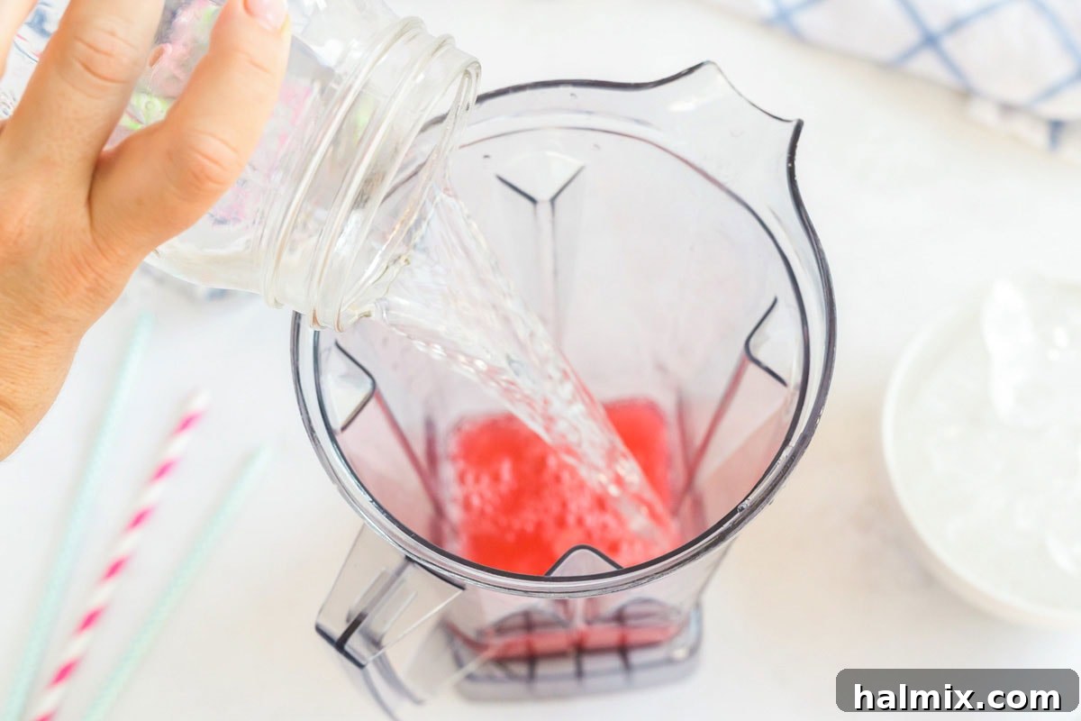 Adding fresh, clear water to the blender, ready to mix with the drink powder and sugar.