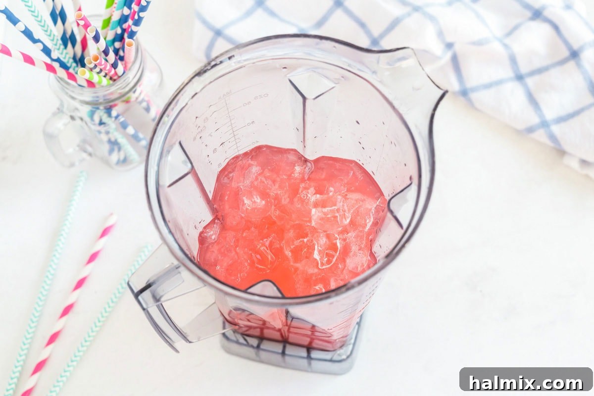 A generous amount of ice cubes filling the blender, preparing for a thorough blending to create the slushie base.