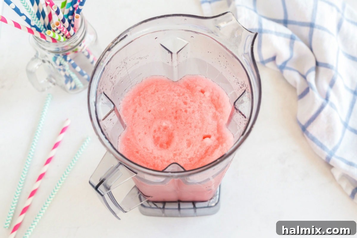 The blender actively processing ingredients, turning ice, water, and drink mix into a perfectly blended slushie.