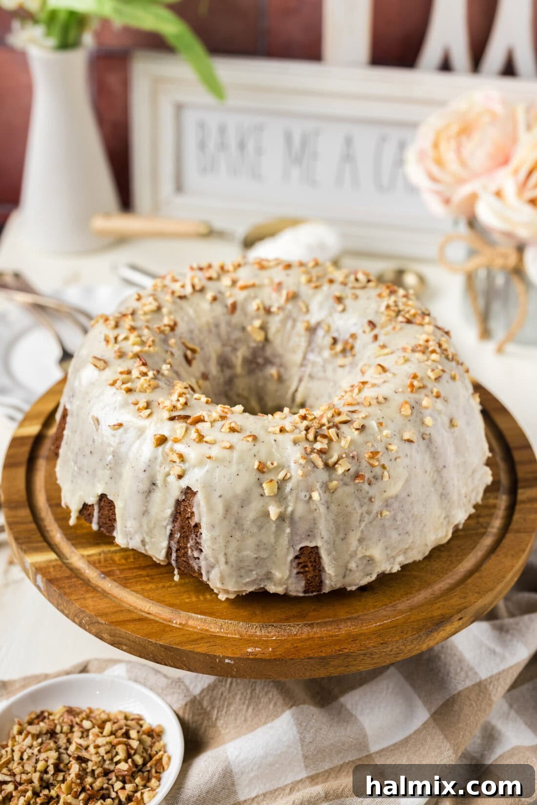 Banana Bundt Cake on a wooden cake stand, beautifully glazed and ready to serve.