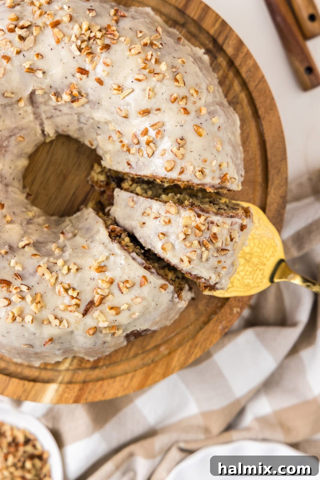 Overhead photo of a Banana Bundt Cake with a slice being removed, showing the rich texture inside.