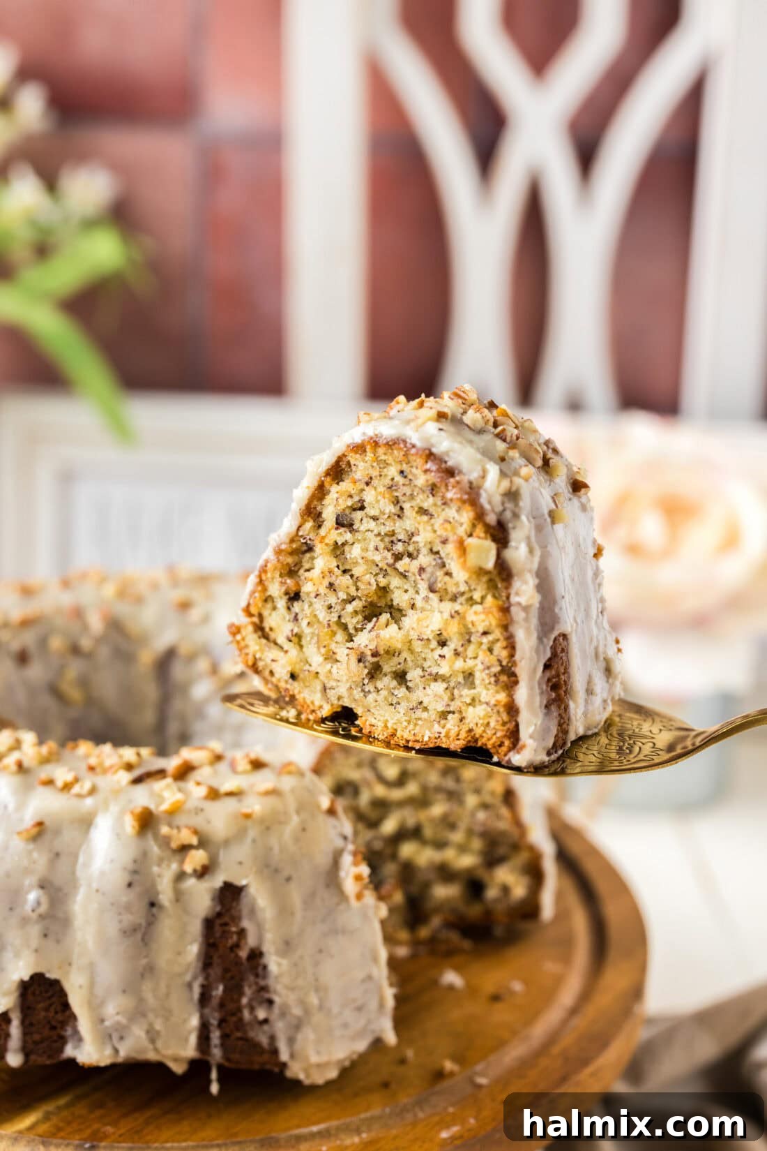 Slice of Banana Bundt Cake on a pie server, showing its moist crumb and rich texture.