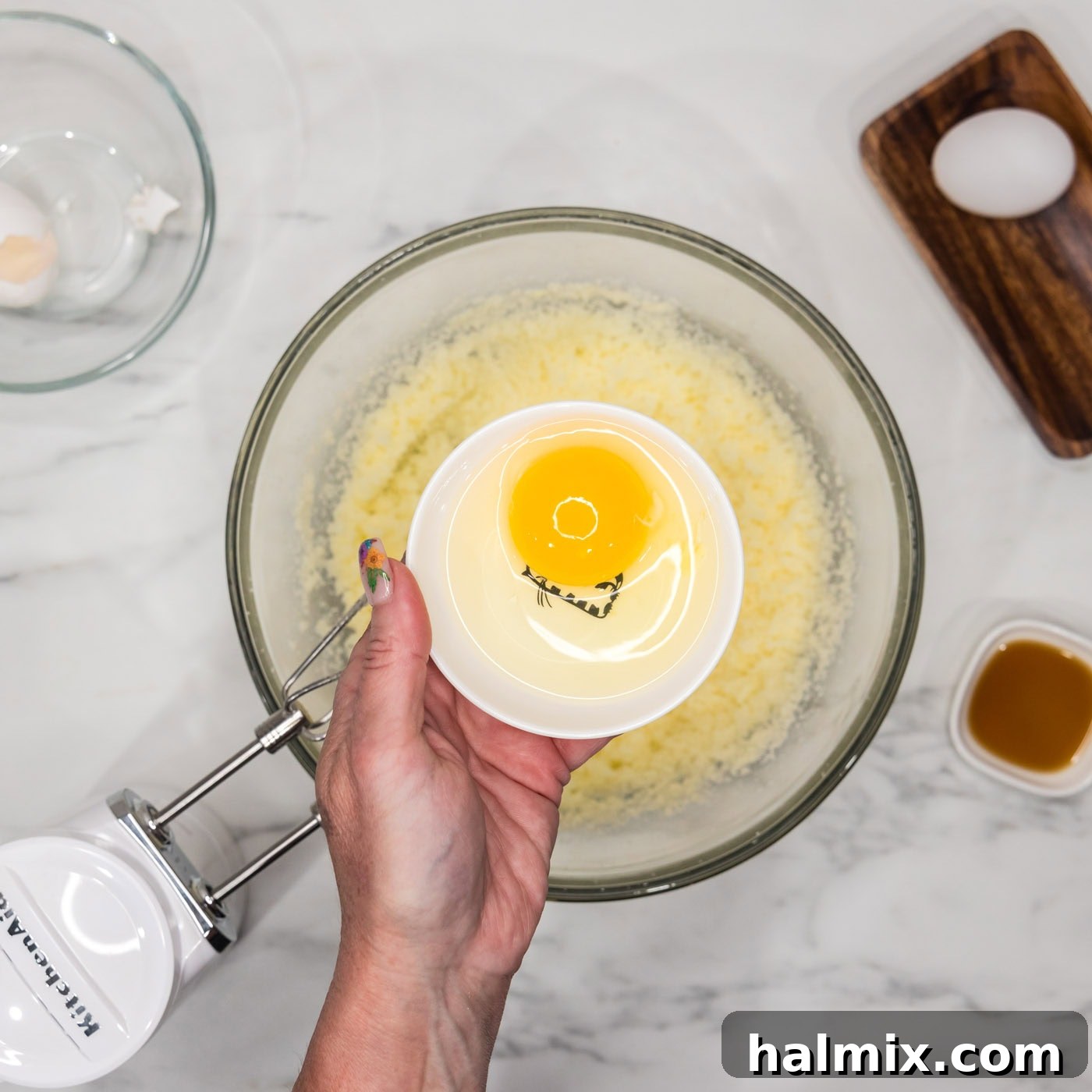 Adding eggs one by one to the bundt cake batter, mixing thoroughly after each addition.