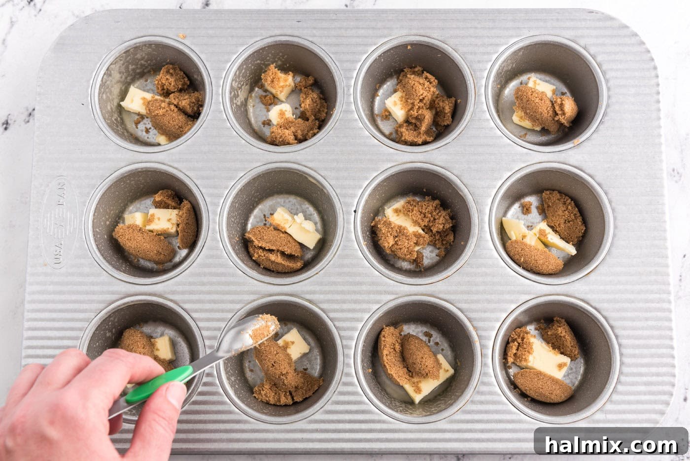 butter and dark brown sugar in wells of a muffin pan