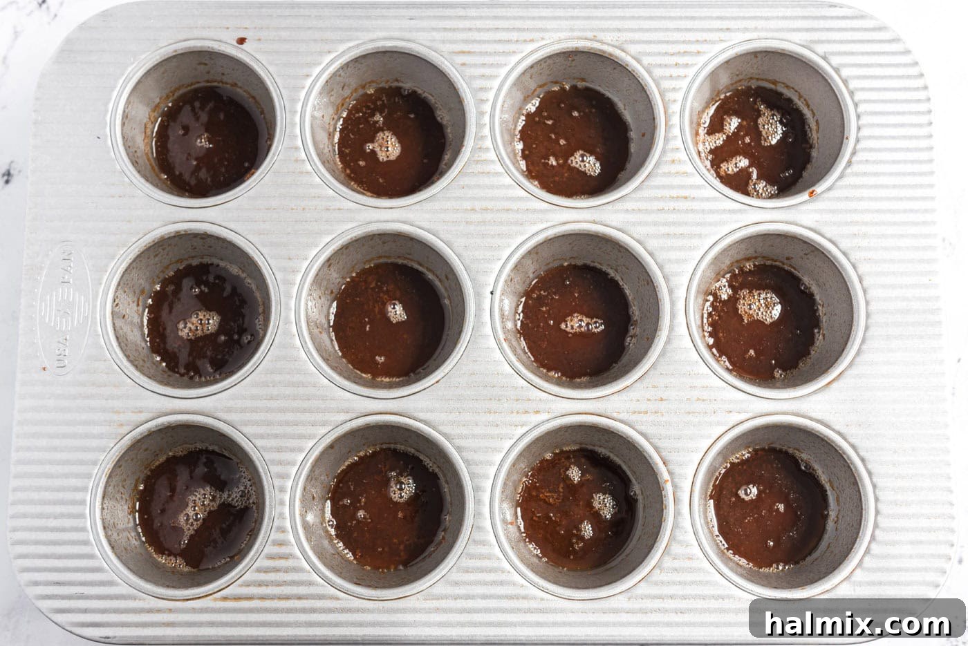 melted butter and brown sugar on bottoms of muffin pan