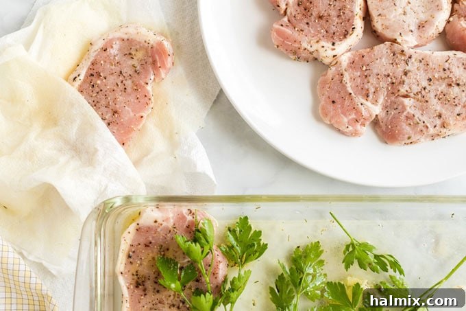 Zesty Lemon Herb Grilled Pork Chops 4 pork chops being dried off with paper towels