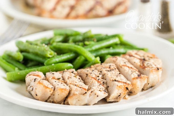 Learn how to make the perfect grilled pork chops. My go-to marinade is very easy and includes lemon juice, olive oil, garlic and a few fresh herbs. sliced pork chop on a plate