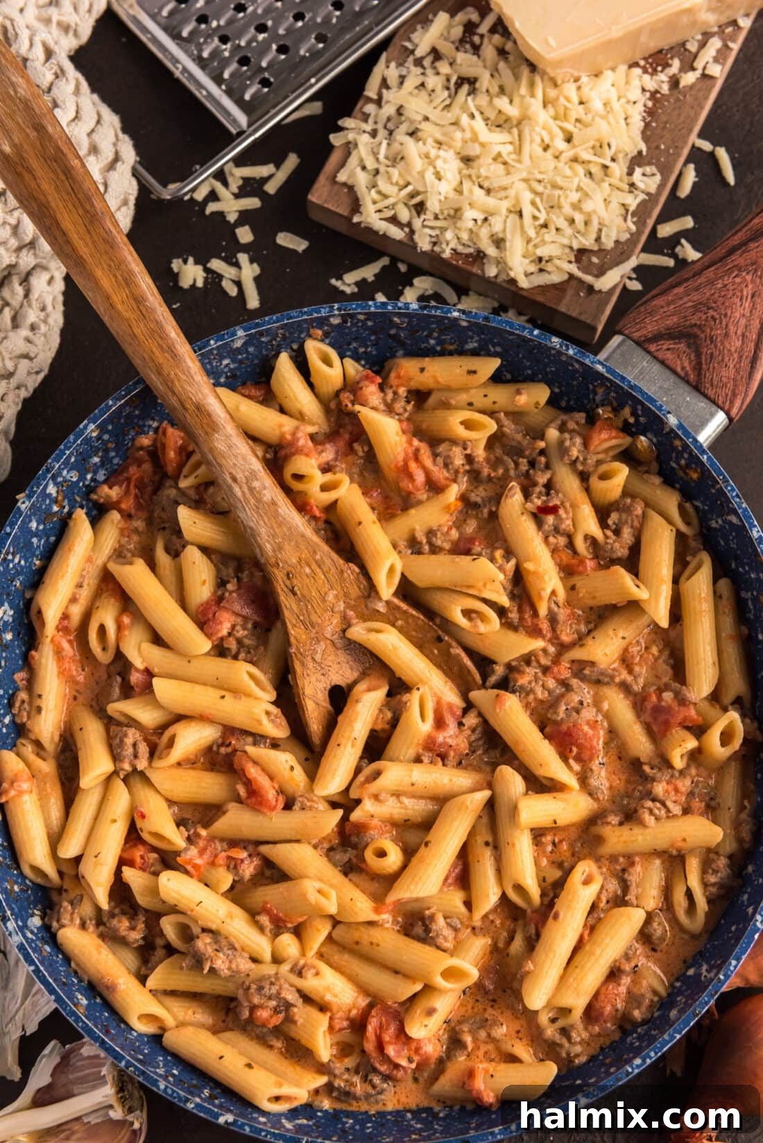 Penne with Tomato Sage Sausage Sauce in a skillet with a spoon