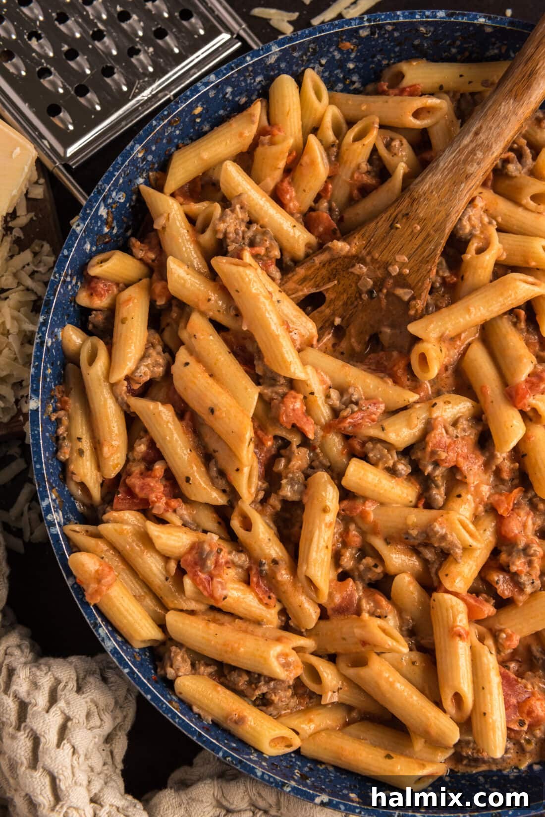 Close up photo of Penne with Tomato Sage Sausage Sauce in a skillet with a spoon