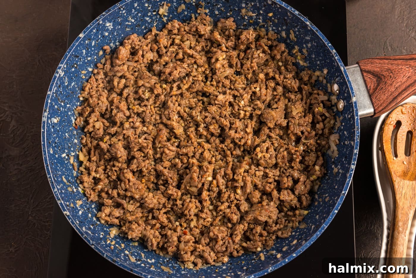 cooked ground pork sausage in a skillet with shallots and garlic