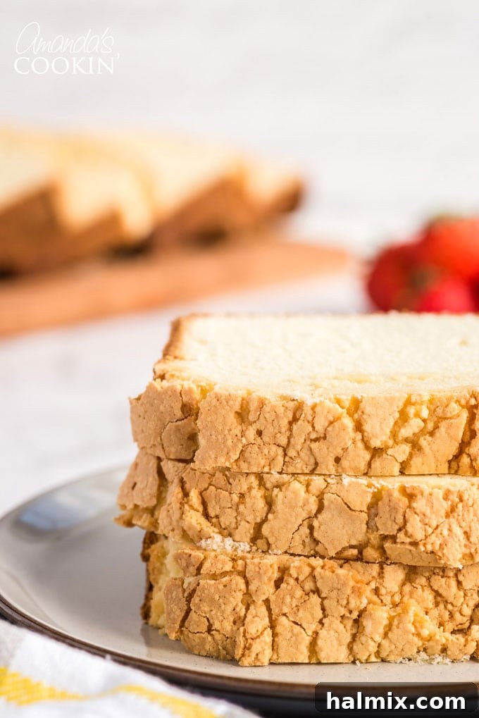 Perfectly Sliced Whipping Cream Pound Cake Two slices of moist, golden-brown pound cake stacked neatly on a white plate, ready to be served.