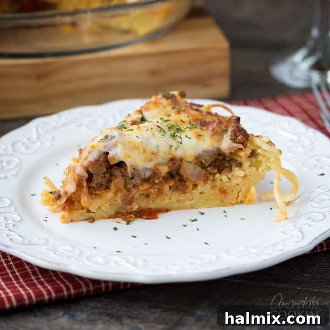 Golden Crust Spaghetti Pie 3 A second view of a slice of spaghetti pie on a white plate, ready to be enjoyed.