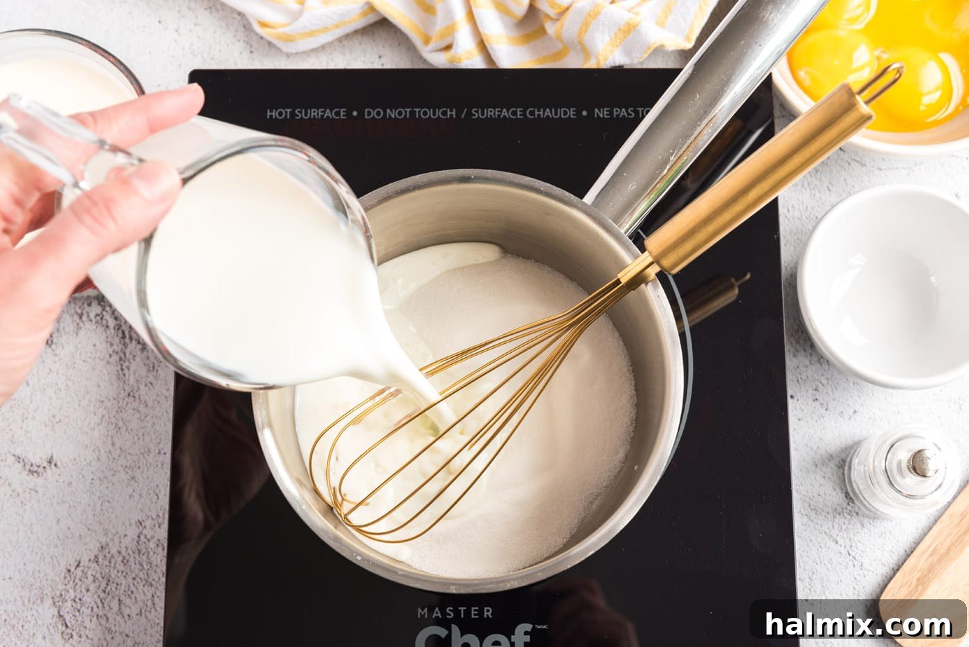 A photo of milk being poured into a saucepan of sugar and salt
