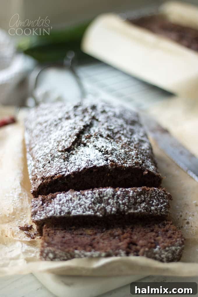 Delicious Chocolate Zucchini Bread A slice of moist chocolate zucchini bread with powdered sugar, ready to be enjoyed.