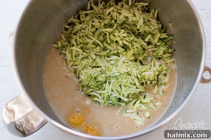Incorporating Zucchini into Chocolate Bread Grated zucchini being gently stirred into the bread batter.