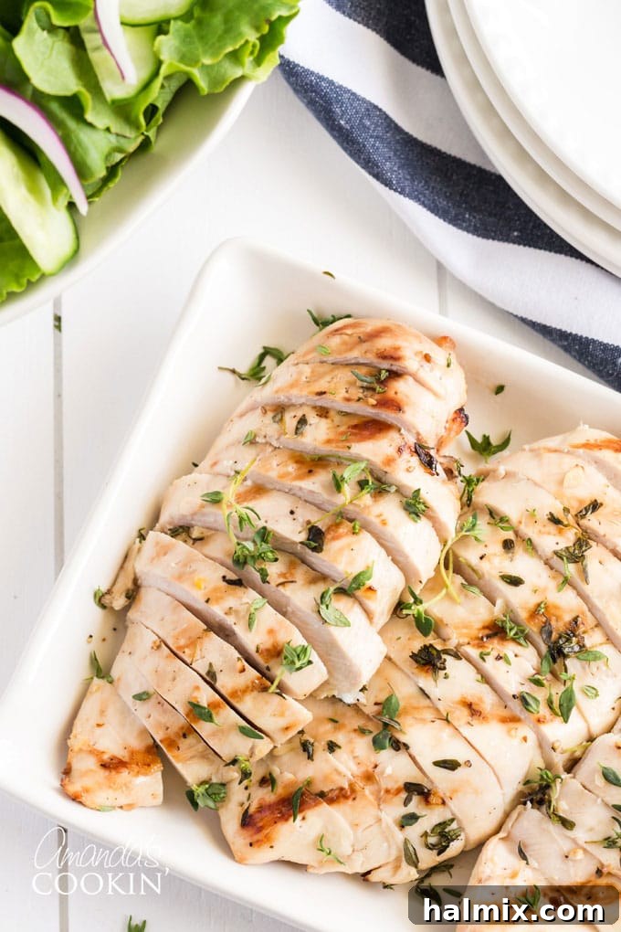 Several juicy grilled chicken breasts, expertly sliced, beautifully presented on a platter.