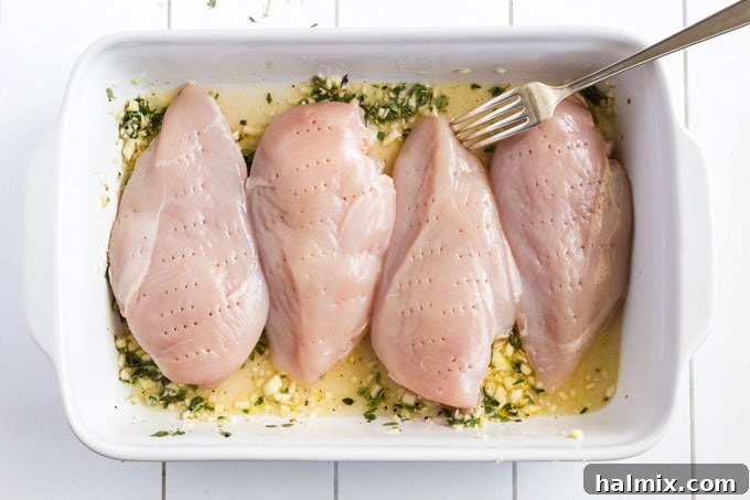 Chicken breasts, pounded to an even thickness and pierced with a fork, ready for marination.
