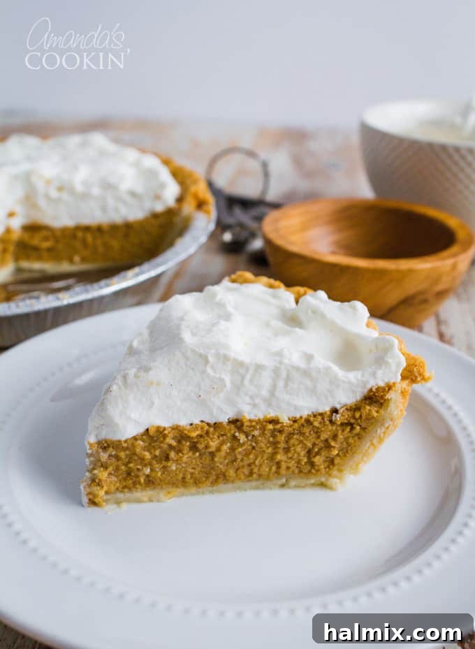 A perfectly sliced homemade pumpkin pie on a white plate, ready to be served, showcasing its creamy texture and golden crust. The background suggests a cozy holiday setting.