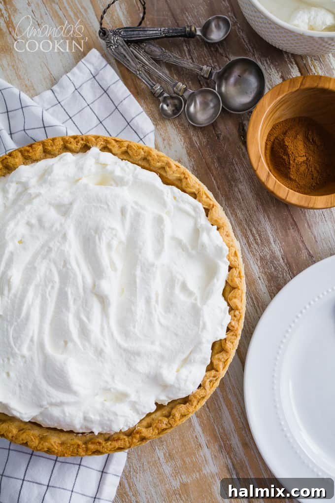 A whole perfectly baked pumpkin pie cooling on a wire rack, its rich, autumnal color hinting at the deliciousness within, ready for holiday serving.