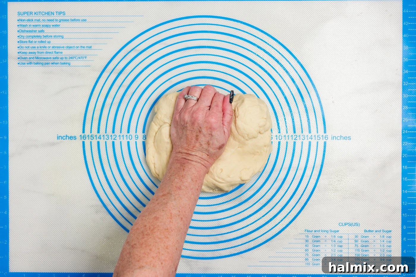 The 60-Minute Loaf 7 Hand pressing bread dough onto a lightly sprayed surface for a brief knead
