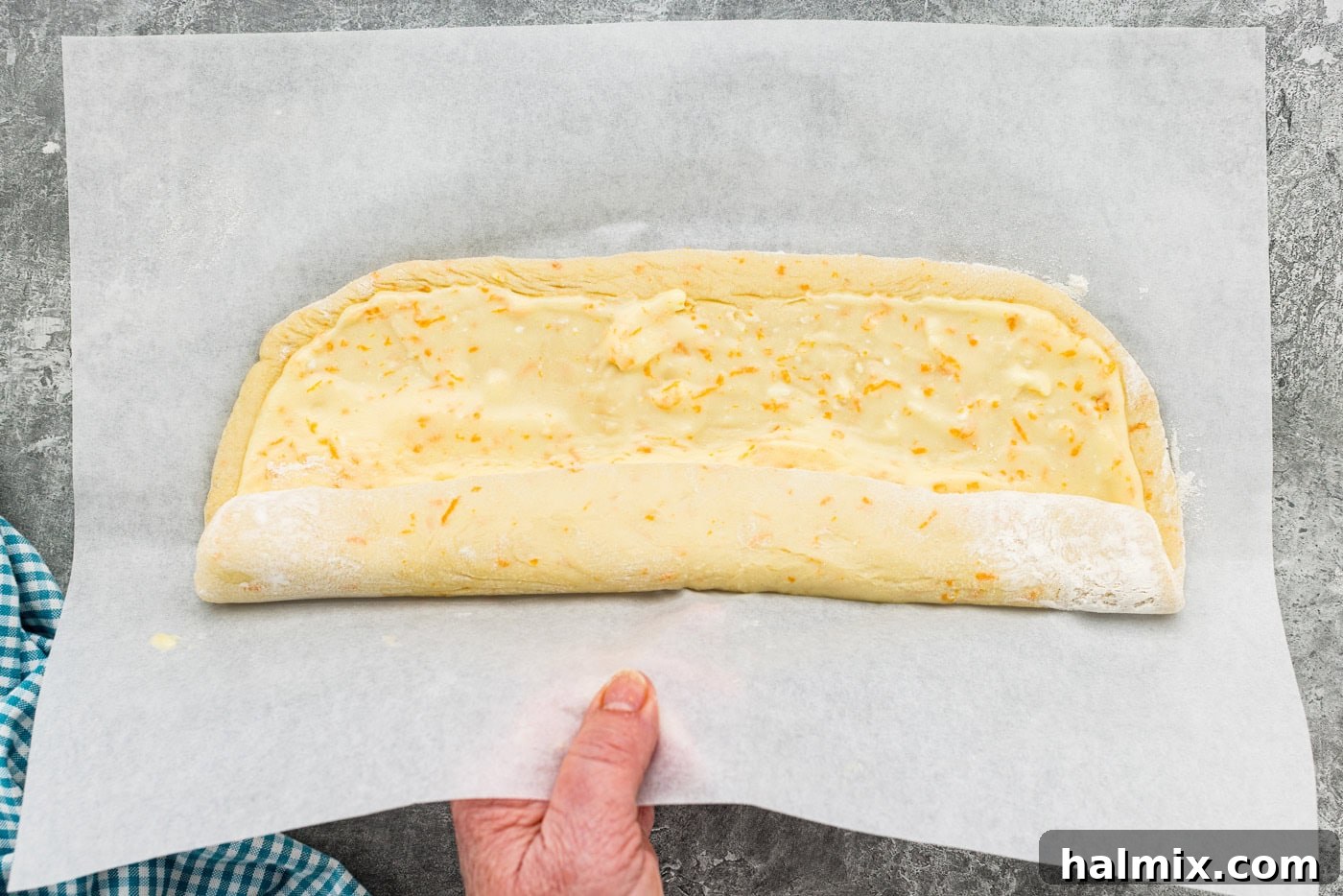 Rolling dough with filling up using parchment paper