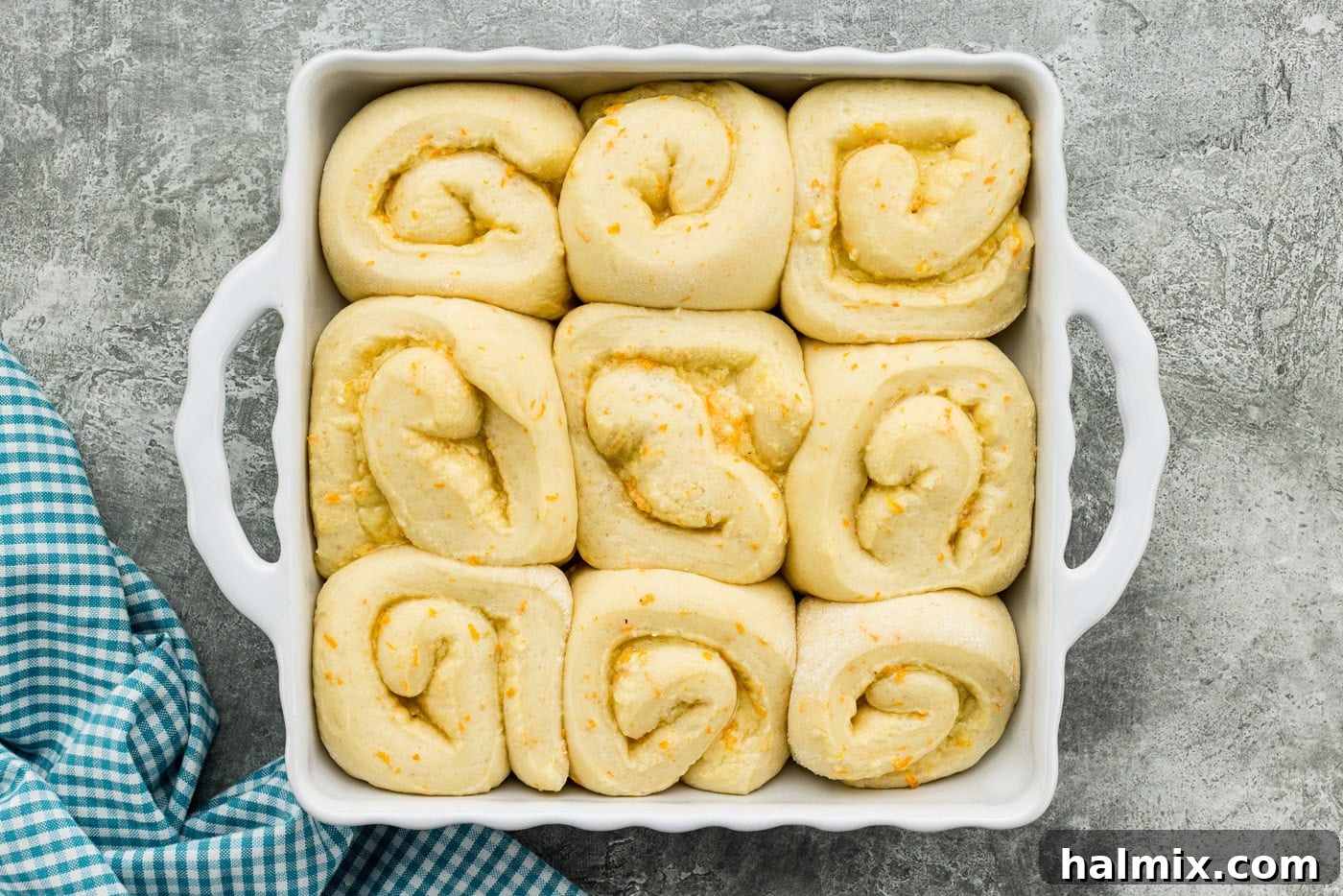 Orange roll dough in a baking dish doubled in size