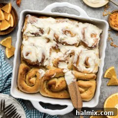Frosting being added to a pan of Quick Orange Rolls