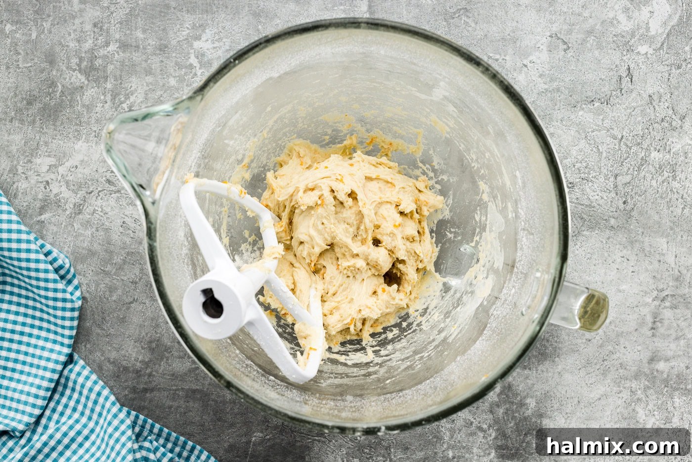 Orange roll dough in a stand mixer bowl with paddle attachment