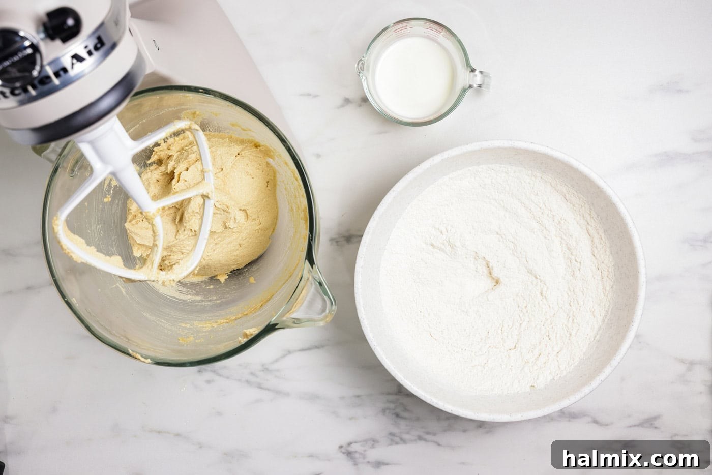 Flour mixture next to cookie dough in a stand mixer