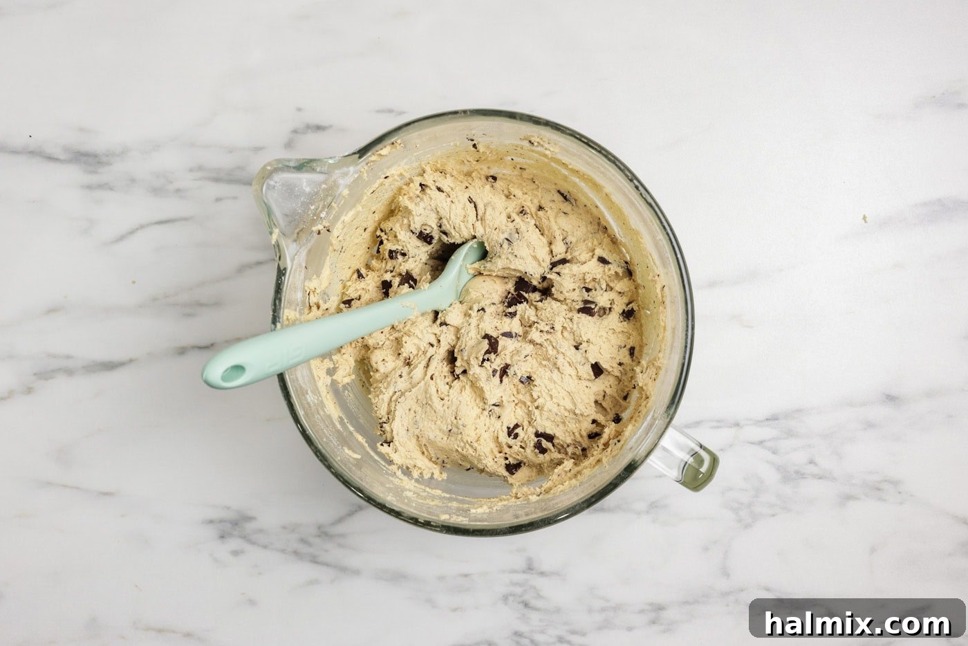 Chopped chocolate folded into cookie dough with a rubber spatula