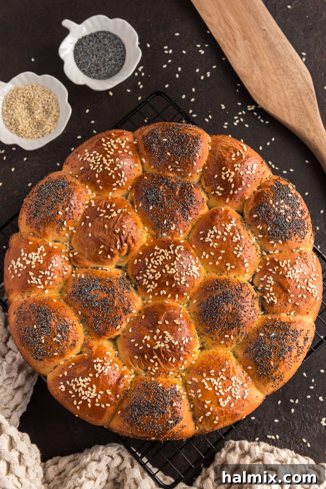 Festive German Bread 2 Overhead photo of golden Partybrot rolls cooling on a wire rack, sprinkled with poppy and sesame seeds.