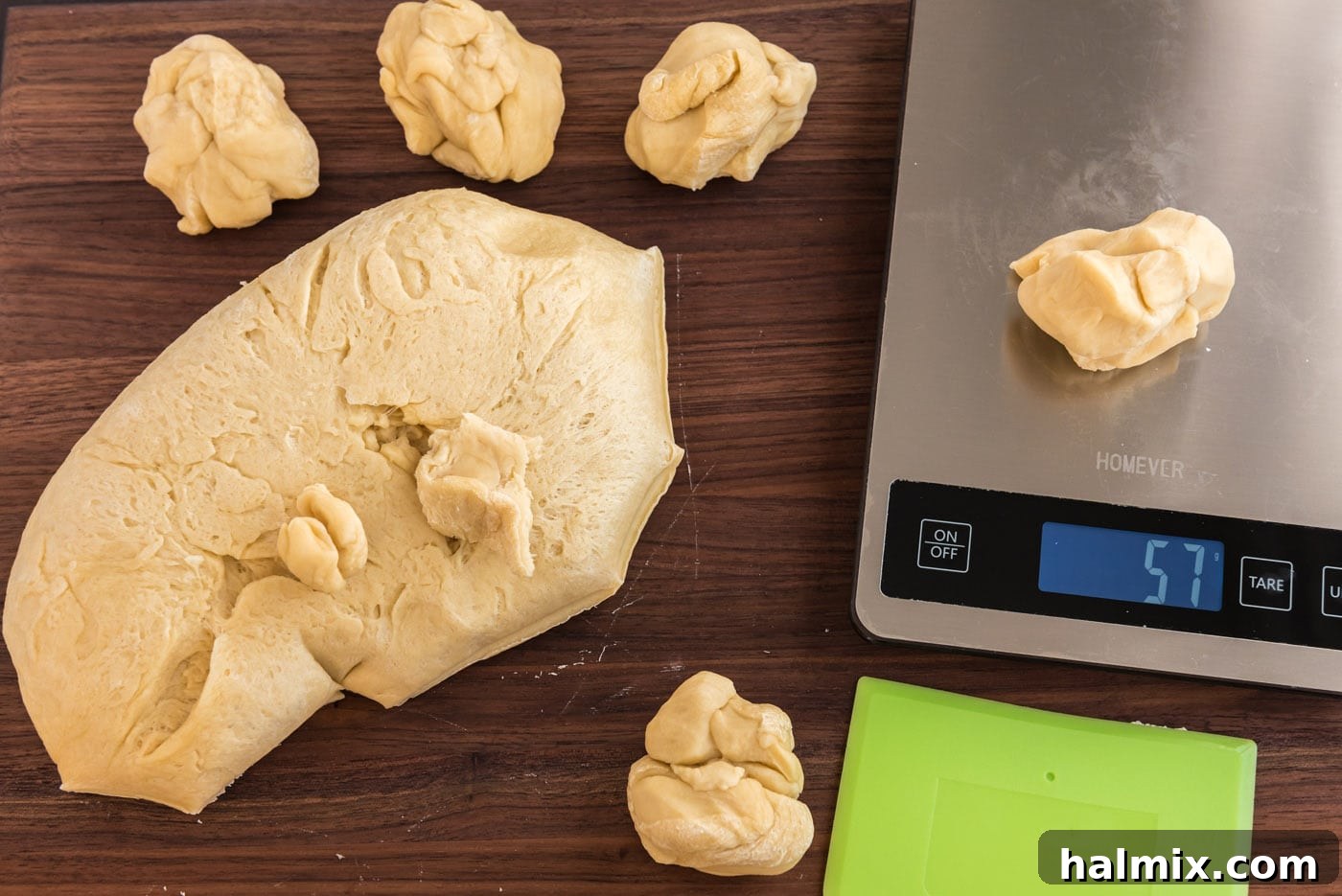 Weighing a portion of yeast dough on a digital kitchen scale for precise division.