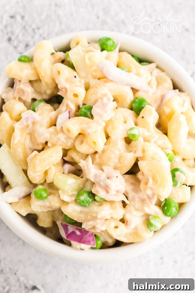 A close-up shot of creamy tuna pasta salad, showing the texture of the macaroni, flakes of tuna, and diced vegetables.