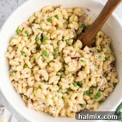A beautiful bowl of creamy Tuna Pasta Salad ready to be served, garnished with fresh herbs.