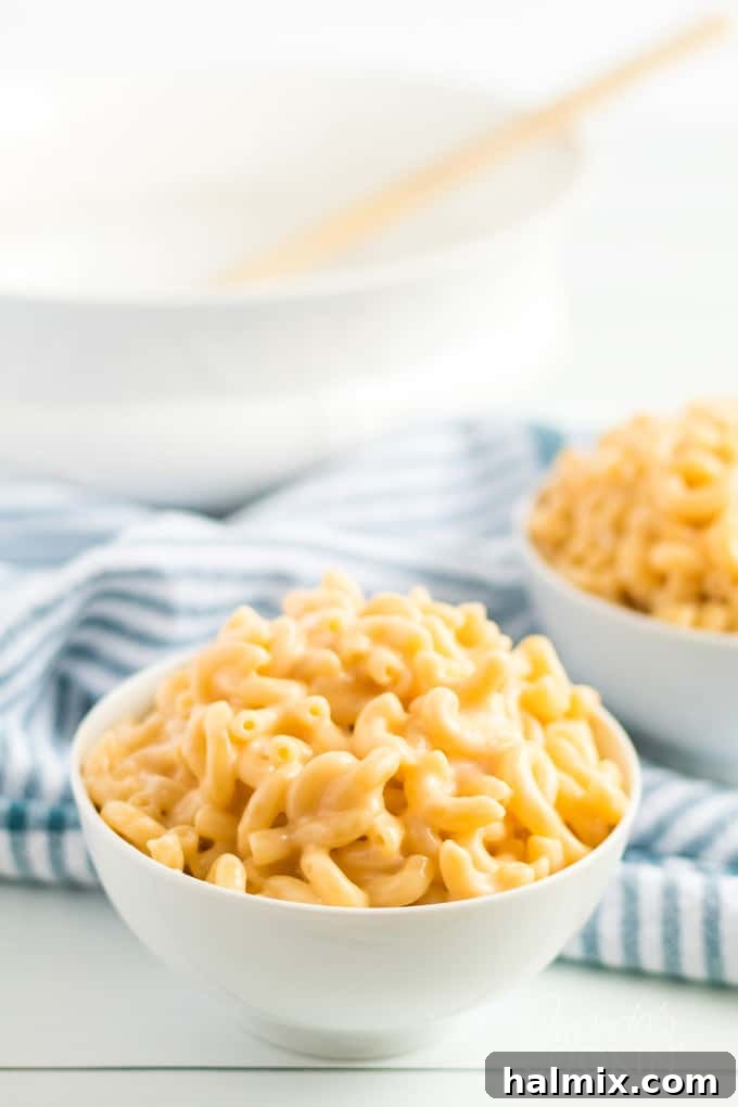 A steaming bowl of classic stovetop macaroni and cheese, garnished with fresh parsley.