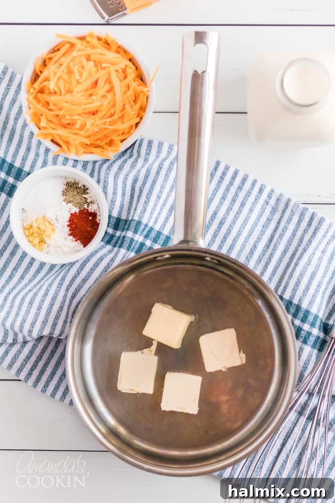 Various ingredients for homemade mac and cheese laid out on a kitchen counter: macaroni, butter, flour, milk, and cheese.