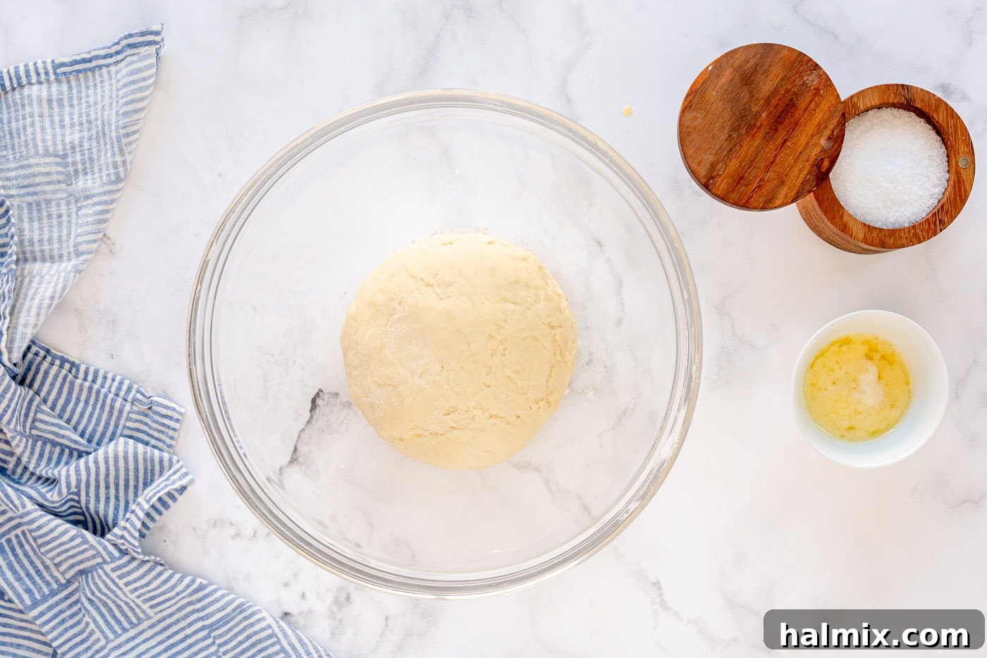 Dough in a bowl, covered with a towel, during its first rise.