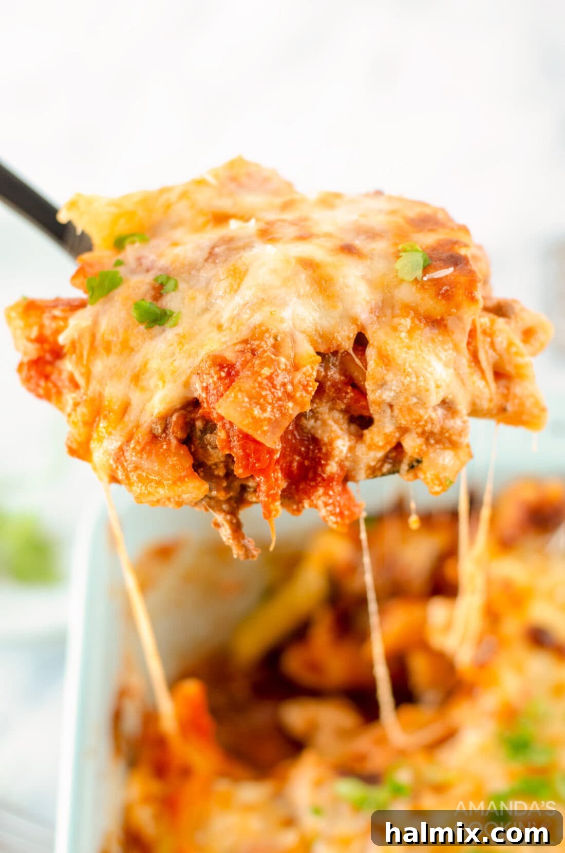 serving spoon of baked ziti