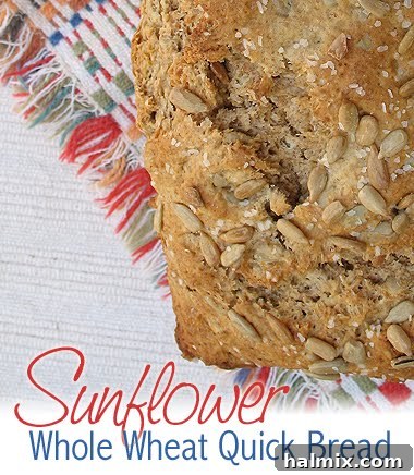A golden-brown loaf of sunflower quick bread, generously studded with sunflower seeds, hinting at its healthy and tasty nature.