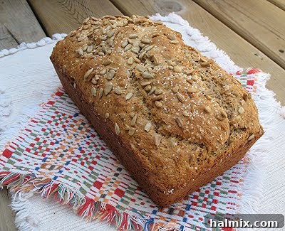 A close-up of the Sunflower Whole Wheat Quick Bread, showcasing its rustic texture and the visible sunflower seeds on the crust.