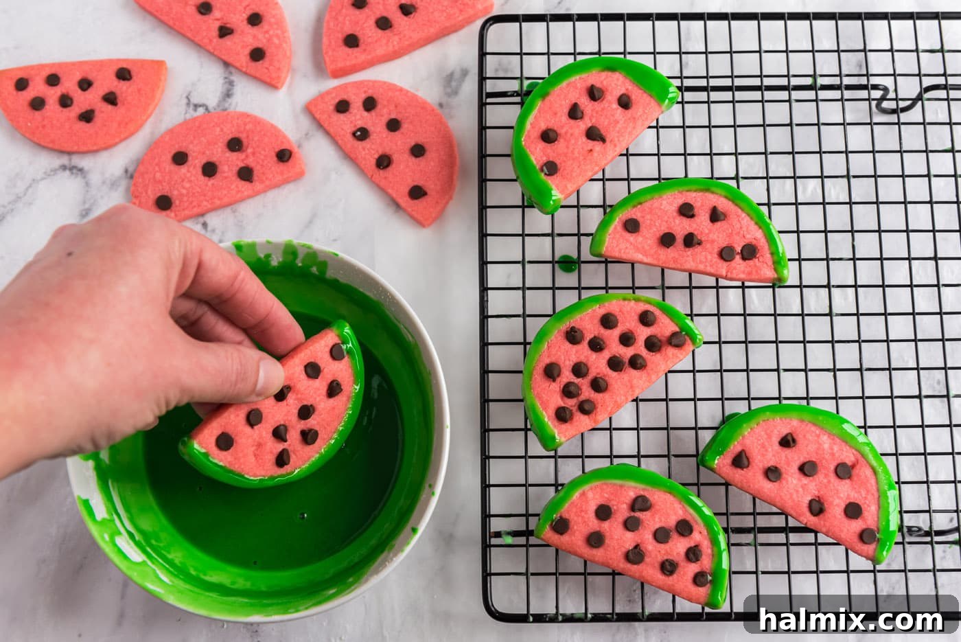 dipping watermelon slice cookies in green glaze