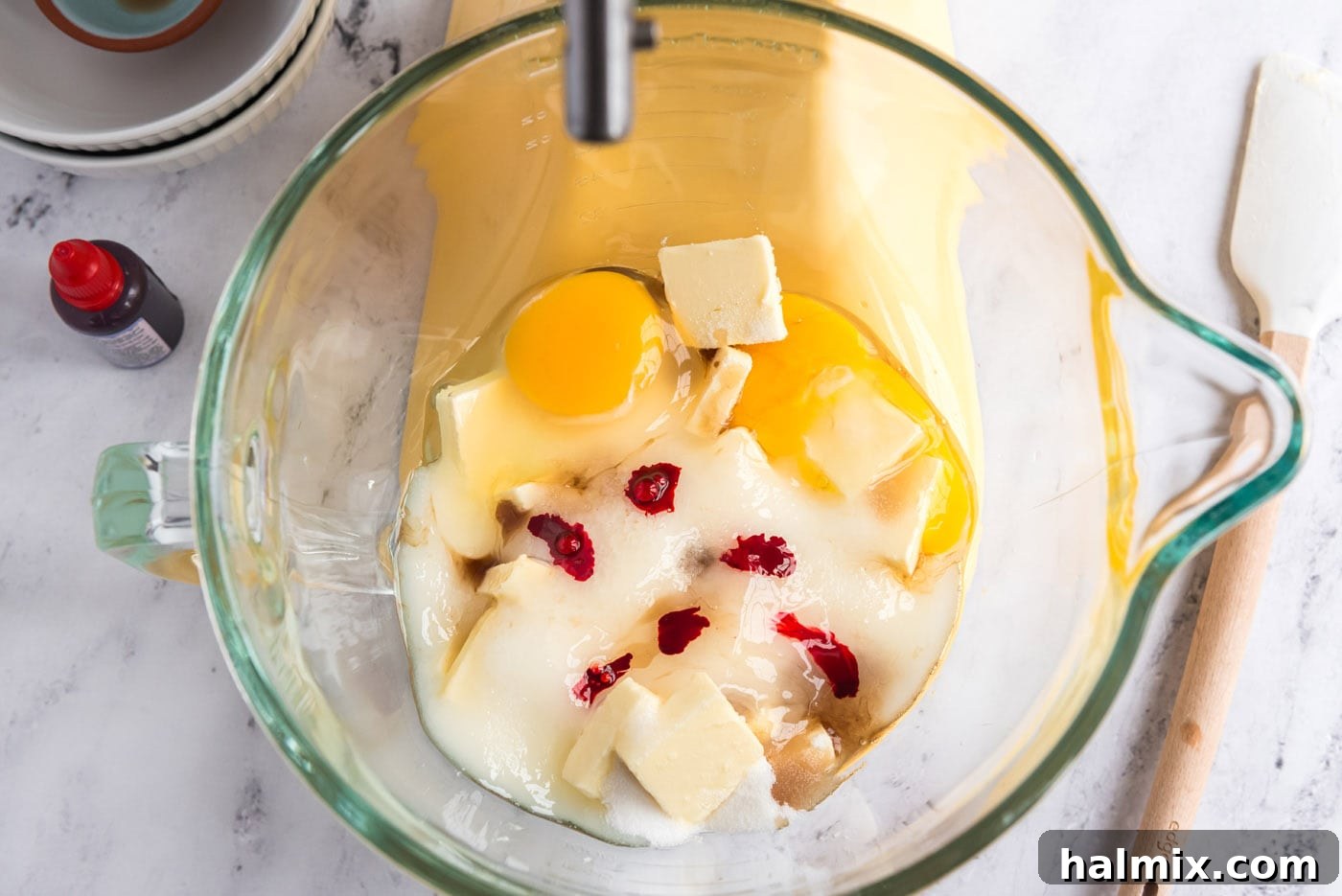 butter, eggs, sugar, and food coloring in a mixer bowl