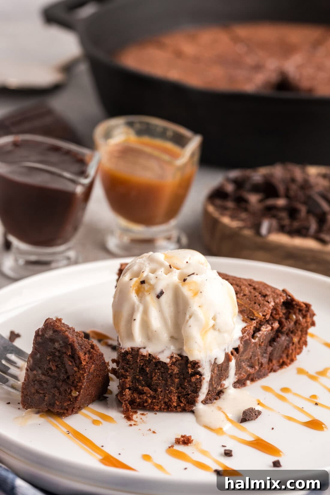 Slice of Cast Iron Skillet brownies on a plate with ice cream on top